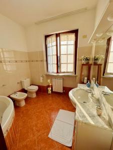 een badkamer met 2 wastafels en een toilet bij La casa del Tiglio in Sarzana