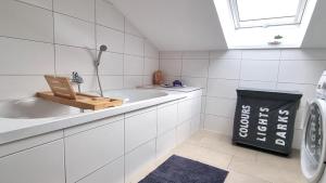 Beauty and Beast 24h-Check-in, 6 Pers, Klima, Massageliege في Cremlingen: حمام ابيض مع مغسلة وغسالة ملابس +32 صورة