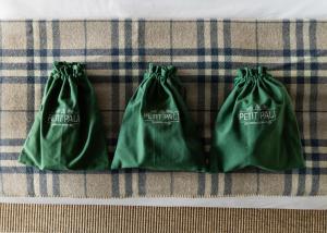 two green bags sitting on top of a table at Le Petit Pali at Ocean Ave in Carmel