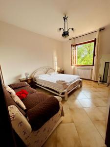 een slaapkamer met een bed, een raam en een bank bij La casa del Tiglio in Sarzana