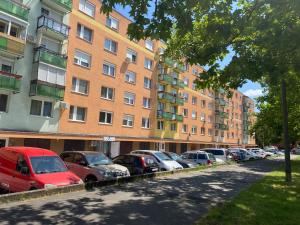 a row of cars parked in front of tall buildings at Sóstó Forest Apartman in Nyíregyháza