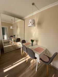 a dining room with a table and chairs and a mirror at Sóstó Forest Apartman in Nyíregyháza