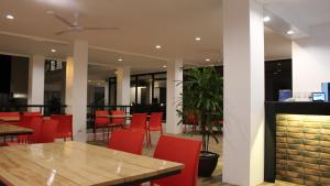 a dining room with red chairs and a fireplace at Be-ing Suites in Davao City