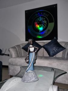 una estatua de una mujer en una mesa de cristal delante de un sofá en Hospedaje Casa Leví, en Cali