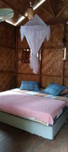 a bedroom with a bed with a mosquito net at Sumatra Jungle Trek In & Orangutan Trips in Bukit Lawang