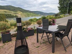 een grill naast een tafel en een tafel en stoelen bij Ferienwohnung Rheinperle in Niederheimbach