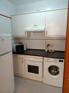 een keuken met een wit fornuis bovenoven naast een wasmachine bij Altamar in Llanes