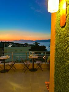 Hotel Ajden by Mira Mare في كساميل: شرفة مع طاولات وكراسي وإطلالة على المحيط