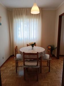 een eettafel en stoelen met een tafel en een raam bij Altamar in Llanes