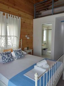 a bedroom with a large white bed with a bathroom at Elafonisos Loft B3 in Elafonisos