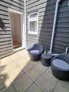 a patio with two bowls and two chairs next to a building at The Cottage @ St Margarets in Ryde