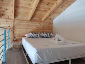 Bett in einem Zimmer mit Holzdecke in der Unterkunft Elafonisos Loft B3 in Elafonisos