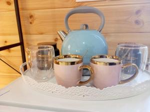 a tray with three coffee cups and a tea kettle at Divine Studios Elafonisos A2 in Elafonisos