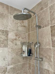 a shower with a shower head in a bathroom at Modern 2 bed flat w parking, dog friendly, central in Bournemouth