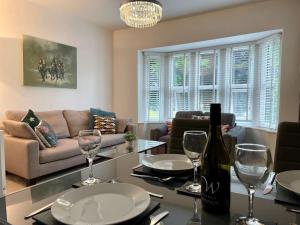 a living room with a couch and a table with wine glasses at Modern 2 bed flat w parking, dog friendly, central in Bournemouth