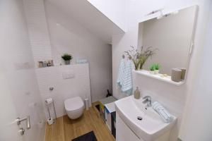 Apartman Eva في سيموني: حمام أبيض مع حوض ومرحاض