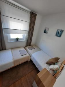 Apartman Eva في سيموني: غرفة صغيرة بسريرين ونافذة