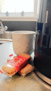 a bag of crisps next to a cup on a counter at 2 Bed Apartment with Free Parking in Chelmsford