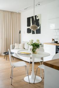 - un salon blanc avec une table et des chaises blanches dans l'établissement Unique & Modern Apartment Zabłocie, à Cracovie