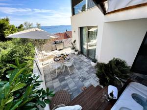 a patio with a table and an umbrella at VILLA ONEUM - Apartment MARE with privat JACUZZI in Omiš