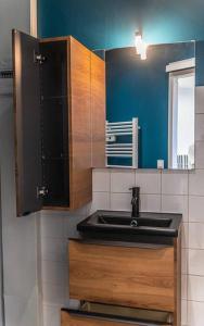 eine Küche mit einem Waschbecken und einem Spiegel in der Unterkunft Studio à Audenge in Audenge