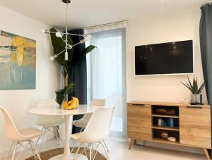 a dining room with a white table and chairs at VILLA ONEUM - Apartment MARE with privat JACUZZI in Omiš