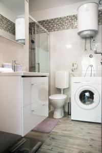 een badkamer met een toilet en een wasmachine bij Apartment Bruna in Solin