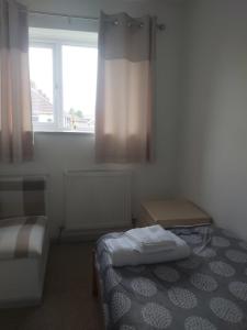 a small room with a bed and a window at Home in Cheltenham in Golden Valley