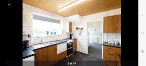 a large kitchen with wooden cabinets and a window at Home in Cheltenham in Golden Valley