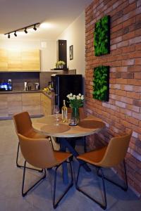 uma mesa e cadeiras numa cozinha com uma parede de tijolos em Apartament Mech & Paprocie em Ustrzyki Dolne