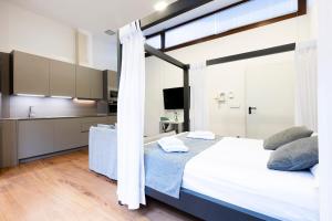 a bedroom with a large white bed and a kitchen at Loft 2 by Basquelidays in Hondarribia