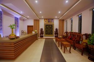 a lobby with a waiting area with benches and windows at New Riverside Hotel in Siem Reap