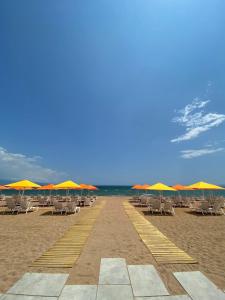 una fila di sedie e ombrelloni in spiaggia di Buka Sandy Beach a Messini
