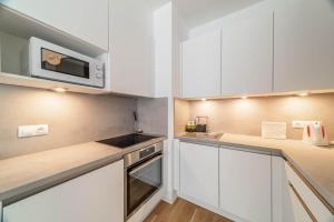 una cucina con armadietti bianchi e forno a microonde di Apartment Michelská a Praga