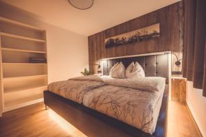 una camera con un grande letto con testiera in legno di Apartment Gipfelblick a Kirchdorf in Tirol