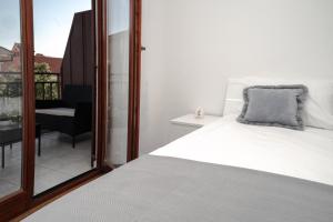 a bedroom with a white bed and a balcony at Apartment Nia in Rabac