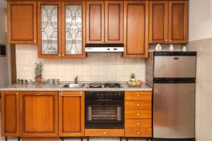 a kitchen with wooden cabinets and a stainless steel refrigerator at Apartment Nia in Rabac