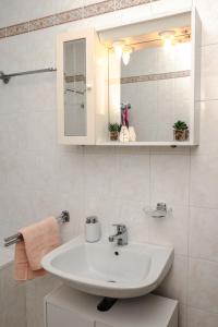 a bathroom with a sink and a mirror at Apartment Nia in Rabac