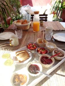 una mesa con una bandeja de comida para el desayuno. en La maison perchée, en Aigues-Mortes