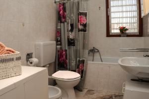 a bathroom with a toilet and a sink and a tub at Apartment Nia in Rabac +17 photos