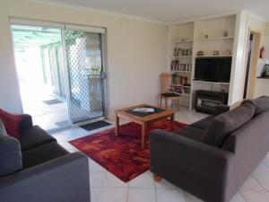 a living room with two couches and a coffee table at Little Ray of Sunshines by the Sea in Edithburgh