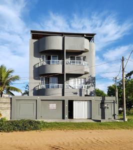 塞拉的住宿－Ed Bertholi - Vista lateral do mar com garagem，前面有栅栏的高楼