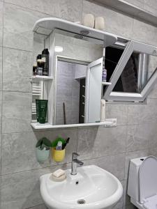La salle de bains est pourvue d'un lavabo et d'un miroir. dans l'établissement Шикарный Апартамент в Батуми, à Batoumi