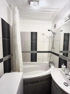a bathroom with a tub and a sink at Elegant Escape apartment - free parking, easy access to City Centre in Bratislava