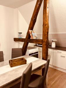une cuisine avec une table en bois, des chaises et un comptoir dans l'établissement Apartment-am-Burgberg, Harztor, à Harztor