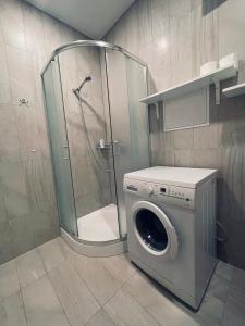 eine Waschmaschine im Bad mit Dusche in der Unterkunft SKY Apartments in Kaunas