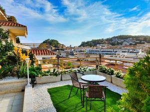 a patio with a table and chairs on a roof at Apartment Luna Tossa De Mar 5mins walking to the beach with sea and castle view big terrace in Tossa de Mar