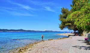 osoba stojąca na plaży w pobliżu wody w obiekcie Naomi w mieście Zadar