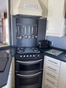 a kitchen with a black stove and utensils at Konies Place Golden Anchor Free WiFi Bedding Included in Chapel Saint Leonards