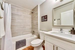 a bathroom with a toilet and a sink and a mirror at Hello Gorgeous Flat near Downtown! in Dallas